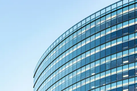 Curved blue glass curtain wall of a commercial building