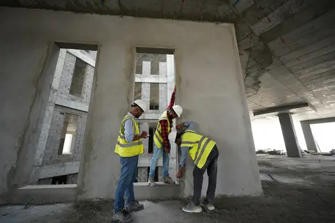 Engineers in high-visibility vests inspecting a gutted concrete interior